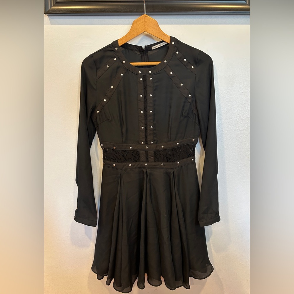 Semi-sheer black dress with a-line flare and lace trim.